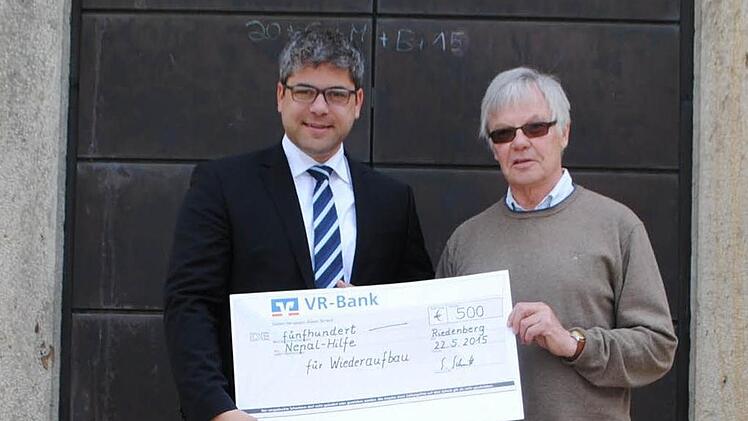 Riedenbergs Pfarrgemeinderatsvorsitzender Stefan Schmitt (rechts) übergibt den Scheck an den BRK-Kreisgeschäftsführer Thomas Stadler.  Foto: Evelyn Schneider
