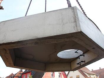 Der Spezialkran hebt die Abdeckung für das Schachtbauwerk an. Allein sie hat ein Gewicht von mehr als sechs Tonnen. Foto: Benedikt Borst