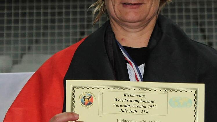Daniela Neumann mit Silbermedaille, Urkunde und Deutschlandfahne.