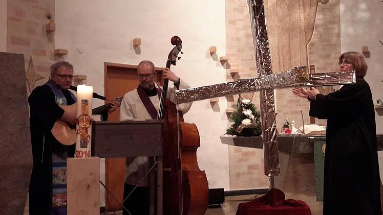 Aus einer massiven Panzersperre wird mit wenigen Handgriffen ein aufrecht stehendes Kreuz. Neben markigen Worten prägte auch eine gewisse Symbolik den ökumenischen Auftaktgottesdienst zum Reformationsjubiläum in der Bad Brückenauer Friedenskirche.  Foto: Rolf Pralle