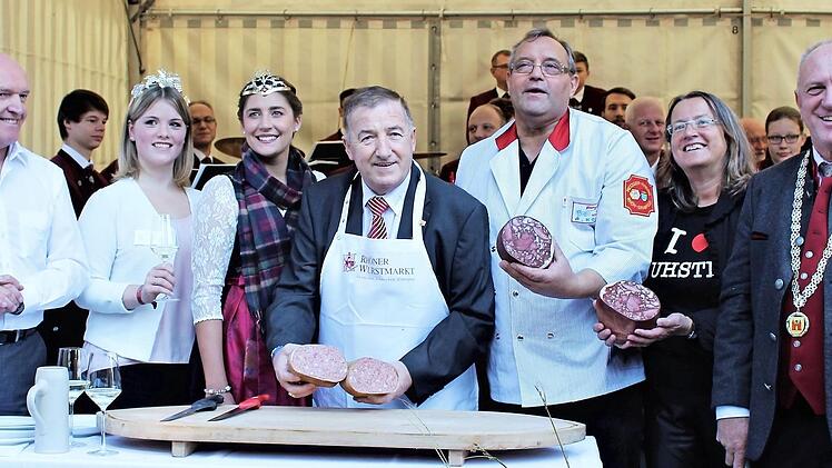 Am Samstagmorgen wurde der neunte Rh&ouml;ner Wurstmarkt mit dem Wurstanschnitt offiziell er&ouml;ffnet (von links): Landrat Thomas Habermann, Hammelburgs Weinprinzessin Annika Kuchenbrod, die Jagdk&ouml;nigin des Bayerischen Jagdverbandes, Lisa M&uuml;ller, der Ehrenpr&auml;sident des Deutschen Fleischerverbandes, Heinz-Werner S&uuml;ss, Rh&ouml;n-Grabfelds Innungs-Obermeister Anton Koob, die Vertreterin des Kommunalunternehmens Tourismus und Marketing Ostheim, Susanne Orf, sowie B&uuml;rgermeister Ulrich Waldsachs.  Foto: Tanja H...