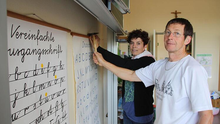 Lehrerin Kirsten Wehner (von links) und Hausmeister Hans Wagner bereiten eines der fünf Klassenzimmer für die Einführung der jahrgangsgemsichten Klassen vor. Wehner hatte sich noch vor der Entscheidung im vergangenen Jahr in einer Fortbildung mit der Unterrichtsform beschäftigt.