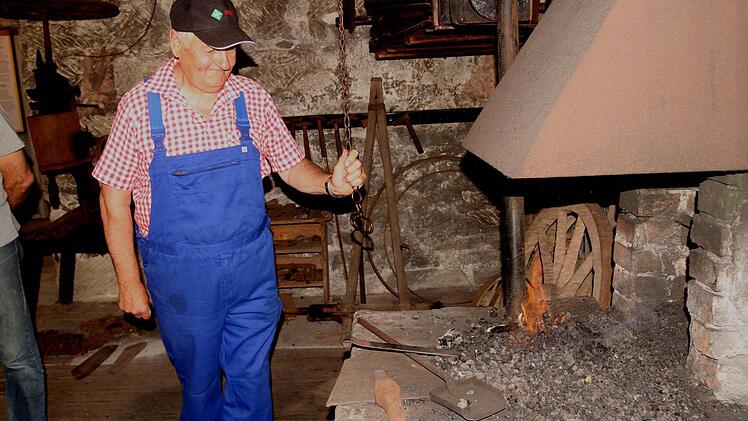 Bild 1: Klaus Eichert zieht am Blasebalg, um zu einer richtigen Glut für das Schmieden des Eisens zu gelangen.
