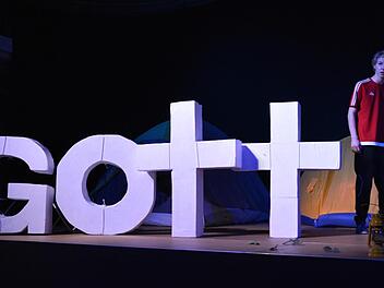 In irgendeiner beklemmenden Form erscheinen die Buchstaben von Gott immer wieder auf dem Bühnenbild.  Foto: Björn Hein