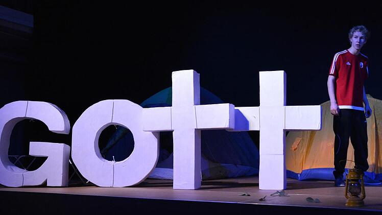 In irgendeiner beklemmenden Form erscheinen die Buchstaben von Gott immer wieder auf dem Bühnenbild.  Foto: Björn Hein
