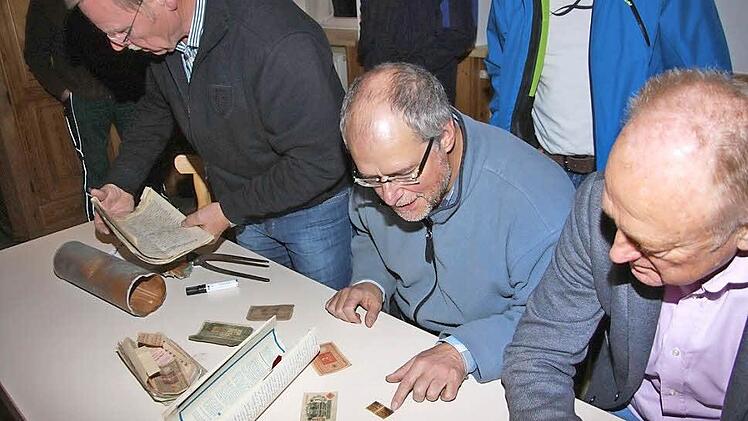 Abermillionen und Milliarden an Notgeld aus den Jahren der Inflation, allerlei schriftliche Zeugnisse und Dokumente aus den Jahren 1927 und 1963 und Berichte über das Zeitgeschehen waren in der Kartusche. Unser Bild zeigt von links Kirchenpfleger Gotfried Behr, Stadtpfarrer Pater Markus Reis und Bürgermeister Helmut Blank.  Fotos: Arnold Nöth