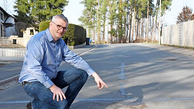 B&uuml;rgermeister Bernd Ruppert begutachtet den Zustand der Weststra&szlig;e in Hausen, die dringend wie viele andere saniert werden muss.