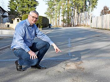 Bürgermeister Bernd Ruppert begutachtet den Zustand der Weststraße in Hausen, die dringend wie viele andere saniert werden muss.