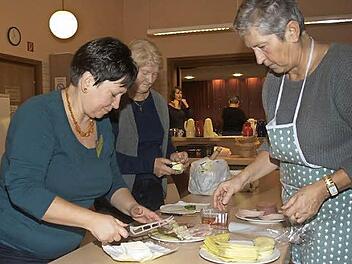 Am frühen Morgen vor dem Frauenfrühstück belegen (von links) Ute Kuhn, Roswitha Duda und Lotte Heuß Wurst- und Käseplatten. Foto: Stefan Geiger