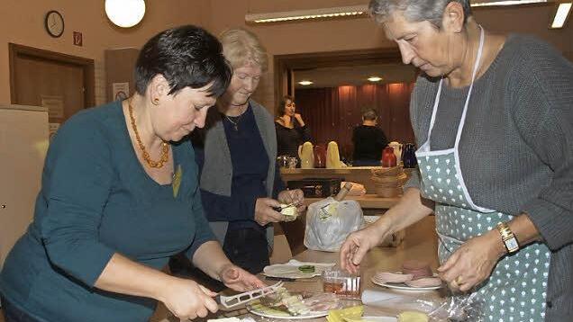 Am frühen Morgen vor dem Frauenfrühstück belegen (von links) Ute Kuhn, Roswitha Duda und Lotte Heuß Wurst- und Käseplatten. Foto: Stefan Geiger