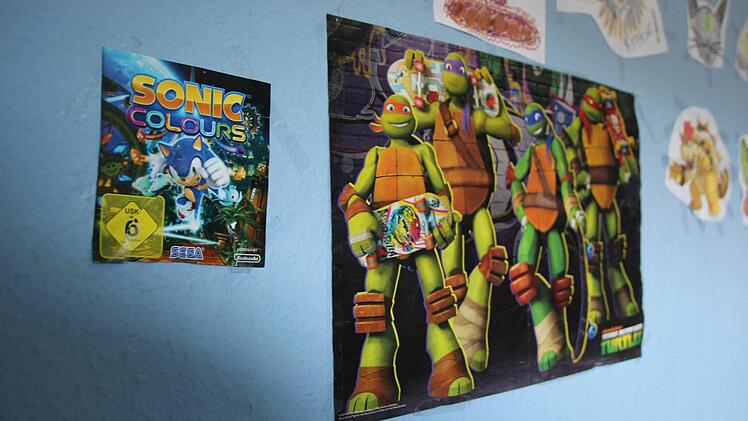 Poster und Zeichnungen an der Wand in einem Kinderzimmer