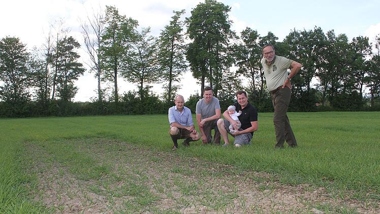 Die kahle Stellen inmitten des Gerstenfelds sind Absicht: Die J&auml;ger Clemens Ulbrich (links) und Harald H&ouml;hn (rechts) freuen sich &uuml;ber die Bereitschaft von Michael und Christoph Jurkat (mit Linus), 17 Lerchenfenster anzulegen. Foto: Sonny Adam