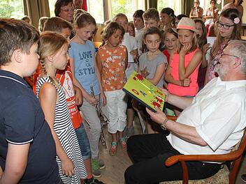 Die 4. Klasse &uuml;berreicht dem Schulleiter ein gebasteltes Buch. Foto: Gerd Klemenz