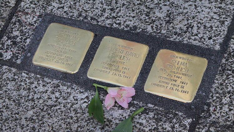 Zum Gedächtnis legt eine Frau Blumen auf alle frisch verlegten Stolpersteine. Foto: Ulrike Müller