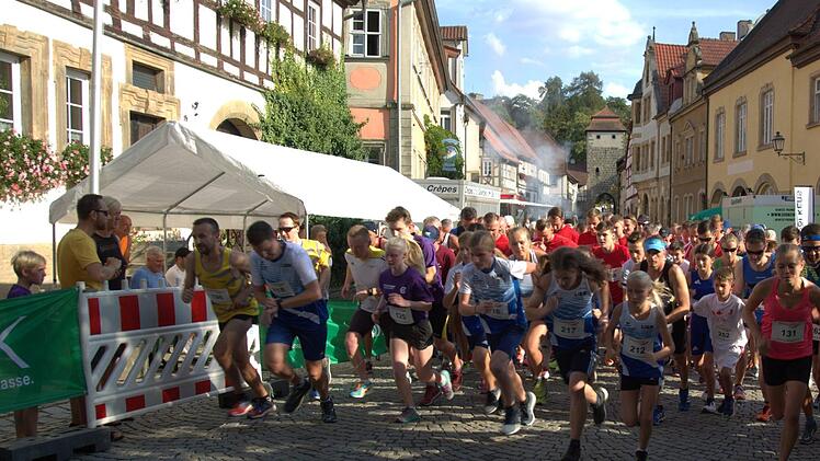 Rund um die Seßlacher Stadtmauer führte nach zweijähriger Pause erneut der Altstadtlauf. Teilnehmer des B-Laufs, die hier starten, liefen vier Runden. Laura Würstlein (SV Heilgersdorf, vorne rechts) kam als schnellste Frau ins Ziel. Felix Mayerhöfer (DJK Dasswang, rechts dahinter) siegte über vier wie über zehn Runden. Foto: Bettina Knauth