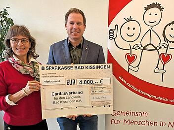 Theresia Schodorf-Friedrich übergibt den Scheck an Caritasvorstand David Hettiger.