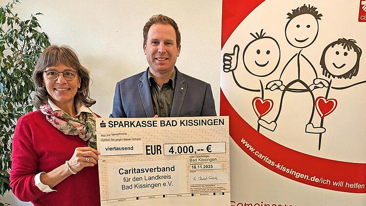 Theresia Schodorf-Friedrich übergibt den Scheck an Caritasvorstand David Hettiger.