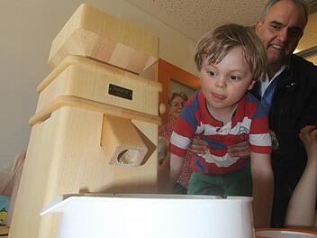 Jonas findet die Mühle spannend, noch spannender aber dann die aus dem Gemahlenen zubereiteten Speisen. Auch Apotheker Georgios Halkias freut sich auf das Naschwerk.  Foto: Michael Busch