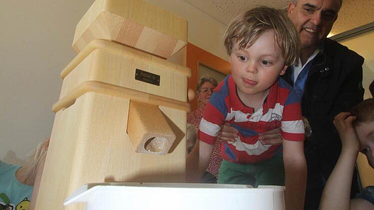 Jonas findet die Mühle spannend, noch spannender aber dann die aus dem Gemahlenen zubereiteten Speisen. Auch Apotheker Georgios Halkias freut sich auf das Naschwerk.  Foto: Michael Busch