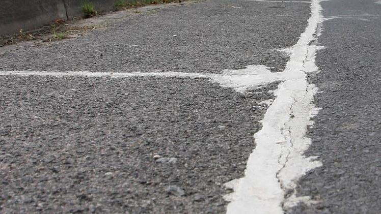 Anwohner begutachten die Schäden. Die Stadt hat die Risse notdürftig ausbessern lassen. Foto: Ralf Ruppert