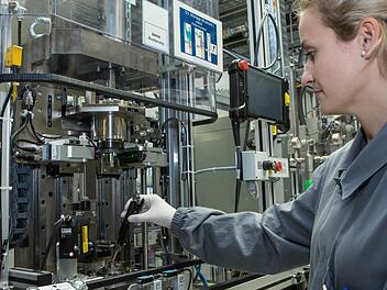 Bosch-Mitarbeiterin Jessica Lang steckt ein Benzin-Hochdruck-Einspritzventil der sechsten Generation in eine Endmontagelinie im Bamberger Werk 3. Foto: Barbara Herbst