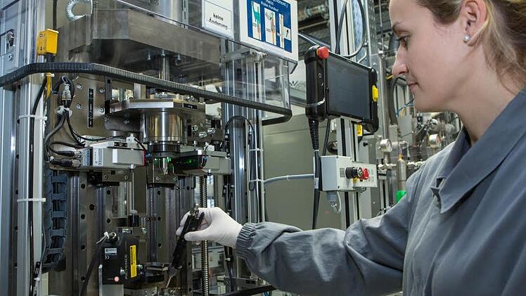 Bosch-Mitarbeiterin Jessica Lang steckt ein Benzin-Hochdruck-Einspritzventil der sechsten Generation in eine Endmontagelinie im Bamberger Werk 3. Foto: Barbara Herbst
