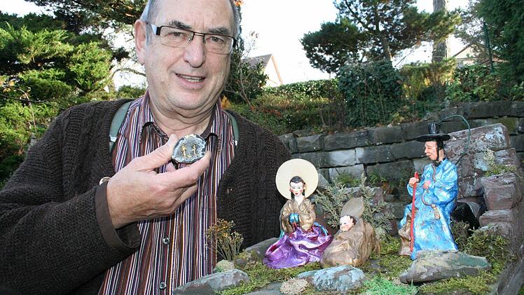 Helmut Dittrich hält in der einen Hand eine der kleinsten, aber wertvollsten Krippen in einer Edelstein-Druse aus dem Grödnertal. Rechts nach japanischen Entwürfen gefertigte Tonfiguren von Rainer Schrüfer aus Wimmelbach - auch bekannt als der "Spitzweg-Krippenbauer" .