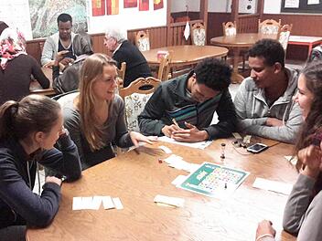 Zur internationalen Spielstätte wird montags der Aufenthaltsraum der Gemeinschaftsunterkunft Volkers. Unter der Leitung von Maja Kirchner (Bildmitte) trifft man sich in lockerer Runde. Nebenbei verbessern bei diesen Begegnungen die Flüchtlinge ihre Sprachkenntnisse. Foto: Rolf Pralle