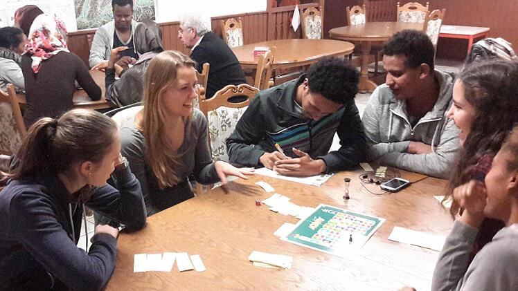 Zur internationalen Spielstätte wird montags der Aufenthaltsraum der Gemeinschaftsunterkunft Volkers. Unter der Leitung von Maja Kirchner (Bildmitte) trifft man sich in lockerer Runde. Nebenbei verbessern bei diesen Begegnungen die Flüchtlinge ihre Sprachkenntnisse. Foto: Rolf Pralle