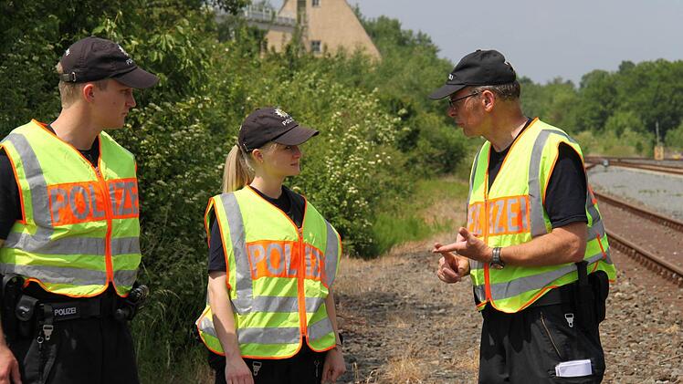 Ausbilder, Polizeioberkommissar Albert Kirchner (rechts) bespricht mit den Auszubildenden, was sie beobachtet haben.