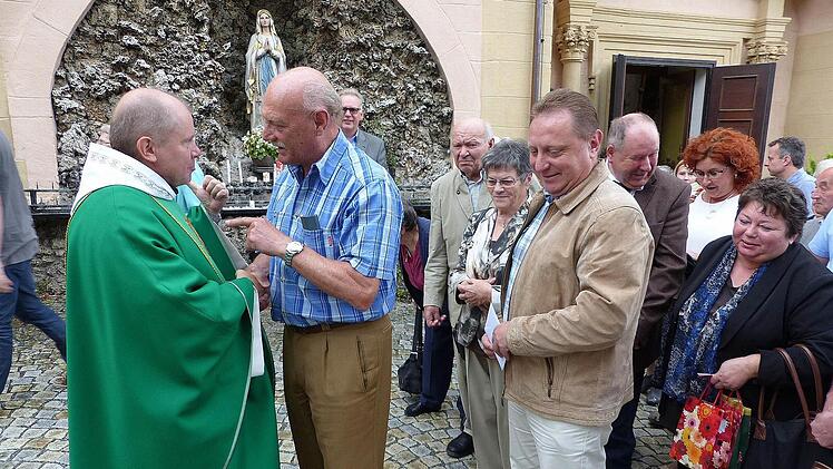 Pater Alard musste nach dem Gottesdienst in der Basilika Marienweiher viele Hände schütteln. Hier verabschiedet sich gerade Reinhard Holhut, dessen Frau Irmgard in Kupferberg den Vorsitz des Pfarrgemeinderats innehalt. Fotos: Klaus-Peter Wulf