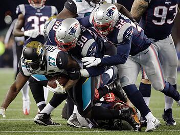New England Patriots - Jacksonville Jaguars in Foxborough (USA). Leonard Fournette (27, l) von den Jacksonville Jaguars im Tackling mit New England Patriots Spielern Malcom Brown (90, M) und Elandon Roberts (52). Titelverteidiger New England Patriots hat erneut das Super-Bowl-Endspiel in der amerikanischen Football-Liga NFL erreicht. Foto: Steven Senne/AP/dpa