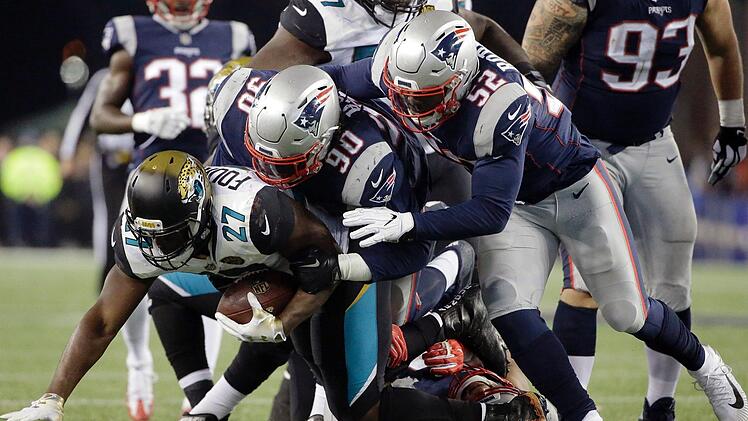 New England Patriots - Jacksonville Jaguars in Foxborough (USA). Leonard Fournette (27, l) von den Jacksonville Jaguars im Tackling mit New England Patriots Spielern Malcom Brown (90, M) und Elandon Roberts (52). Titelverteidiger New England Patriots hat erneut das Super-Bowl-Endspiel in der amerikanischen Football-Liga NFL erreicht. Foto: Steven Senne/AP/dpa