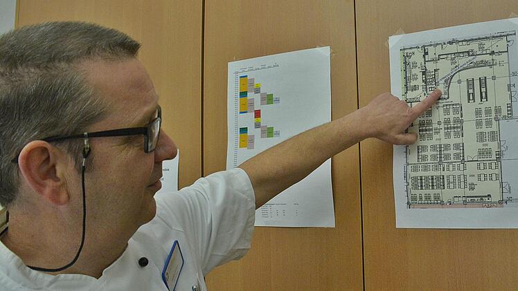Küchenleiter Joachim Stengler zeigt den Plan im neuen Mitarbeiter-Casino. Hier wird am Rande das Buffet aufgebaut. Eine etwa 20 Meter lange Theke mit allen Köstlichkeiten. Foto: Hanns Friedrich