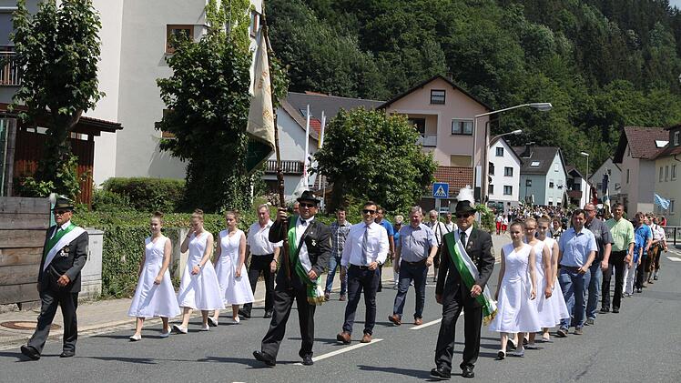 Die Fahne mit Begleitern des gastgebenden Vereins führte den Schützenumzug durch die Flößerstadt Wallenfels an. Stark vertreten waren auch der Stadtrat und der Pfarrgemeinderat. Foto: Michael Wunder