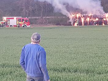 Der Bauer vor dem riesigen Strohballenhaufen, der am Donnerstag Abend in Flammen stand. Der Landwirt war schockiert. Foto: Susanne Will