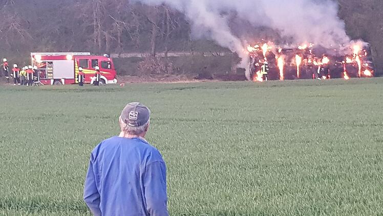 Der Bauer vor dem riesigen Strohballenhaufen, der am Donnerstag Abend in Flammen stand. Der Landwirt war schockiert. Foto: Susanne Will