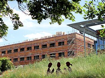 Fast aus dem Grünen heraus erhebt sich der dreistöckige Neubau des Friedrich-Rückert-Gymnasiums neben der Mensa (rechts).  Fotos: Günther Geiling