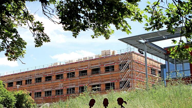 Fast aus dem Grünen heraus erhebt sich der dreistöckige Neubau des Friedrich-Rückert-Gymnasiums neben der Mensa (rechts).  Fotos: Günther Geiling