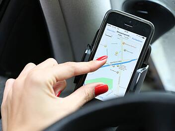 Aus einer Handyhalterung rutschte das Smartphone in den Fu&szlig;raum - und verursachte so einen Unfall. Symbolfoto: Bodo Marks, dpa