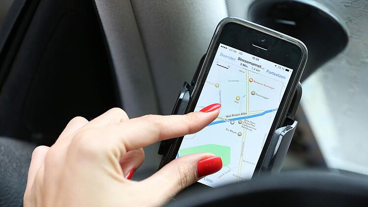 Aus einer Handyhalterung rutschte das Smartphone in den Fu&szlig;raum - und verursachte so einen Unfall. Symbolfoto: Bodo Marks, dpa