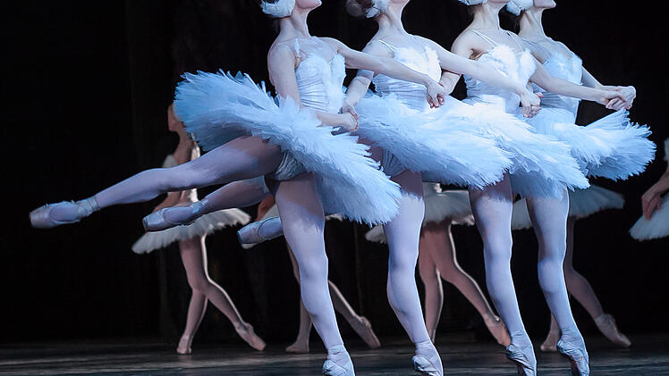 beauty, agility, dancing concept. arm in arm four elegant and graceful female ballet dancers, playing the roles of petite swans, moving, dancing and jumping synchronously