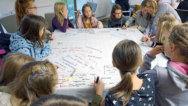 Die Kinder schrieben auf die Tischdecken, was ihnen zu bestimmten Fragen einfiel.  Fotos: Richard S&auml;nger