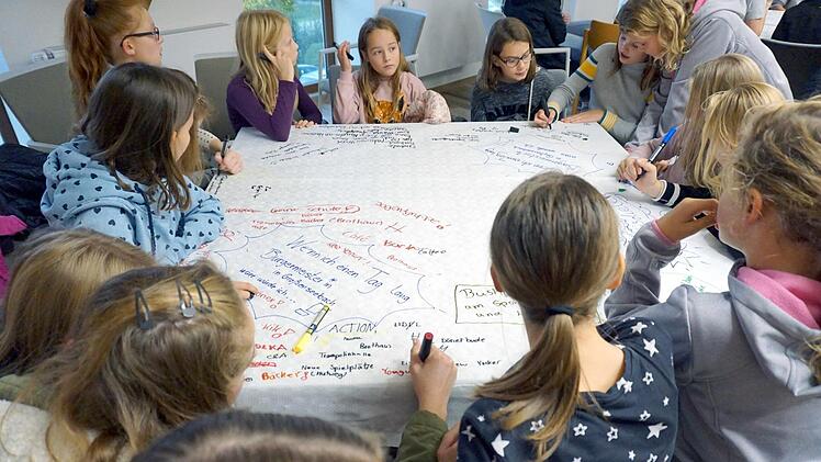 Die Kinder schrieben auf die Tischdecken, was ihnen zu bestimmten Fragen einfiel.  Fotos: Richard Sänger