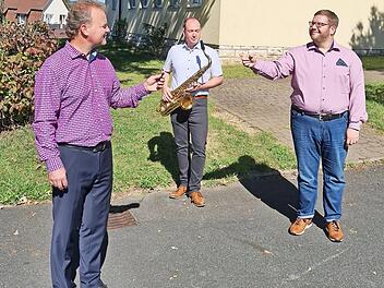 Wojciech Grabietz übergibt vor dem Musikvereinsheim den Dirigentenstab an Johannes Raum, dahinter Christian Hetz. Foto: Carmen Schwind