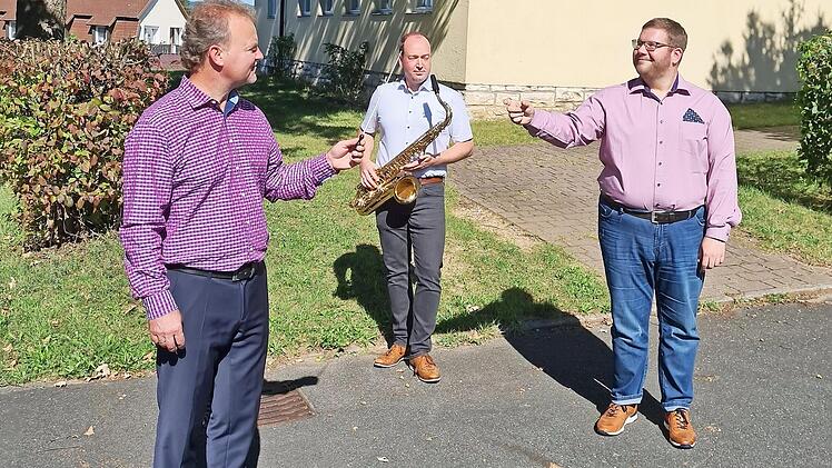 Wojciech Grabietz übergibt vor dem Musikvereinsheim den Dirigentenstab an Johannes Raum, dahinter Christian Hetz. Foto: Carmen Schwind