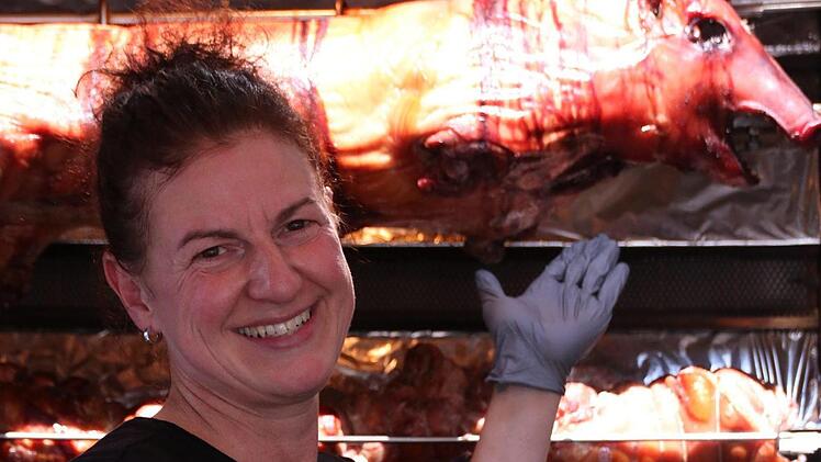 Susanne Flick teilt sich ihre Bude mit einem 18 Kilo schweren Spanferkel. Foto: Teresa Hirschberg