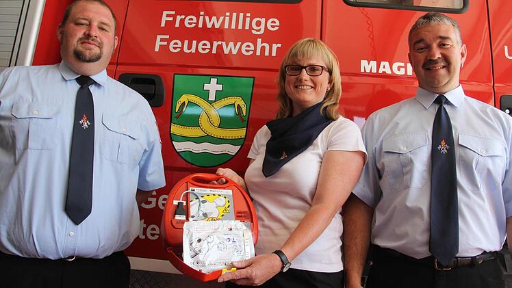 Voller Freude hatten der Feuerwehrvereinsvorsitzende Udo Schwappach, Feuerwehrreferentin Sandra Schramm und Kommandanten Ralph Morgenroth am 7. Juni 2014 den Defibrillator präsentiert. Foto: Helmut Will