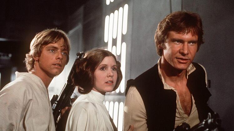 Mark Hamill (links) als Luke Skywalker, Carrie Fisher als Leia Organa und Harrison Ford als Han Solo  waren die Helden der ersten Star Wars-Trilogie.