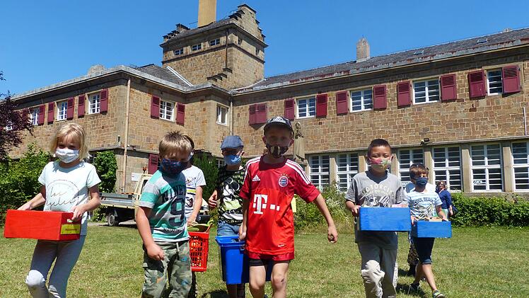 Sie helfen beim Umzug: die Kinder (von links) Lena, Dominik, Elias (verdeckt), Emil, Sam, Huy Ahn, Salim, Sarah (verdeckt) aus der Grundschulbetreuung in Zeil. Leiterin Susanne Langer (rechts) begleitet die Schar auf dem Weg zur Grundschule.  Klaus Schmitt
